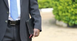 man in black suit jacket holding briefcase